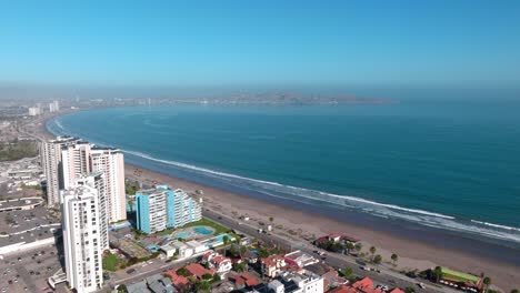 Dolly-in-aerial-view-of-exclusive-buildings-and-the-waterfront-of-La-Serena,-Chile-on-a-sunny-day