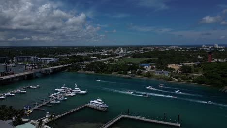 Aerial-Dolly-Shot-Over-the-Indian-River-in-Florida-with-Speed-Boats-Traveling-Towards-a-Bridge
