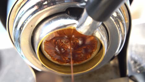 Low-angle-cinematic-close-up-view-capturing-the-channel-from-coffee-extraction,-specialty-single-origin-espresso-extracting-from-the-machine