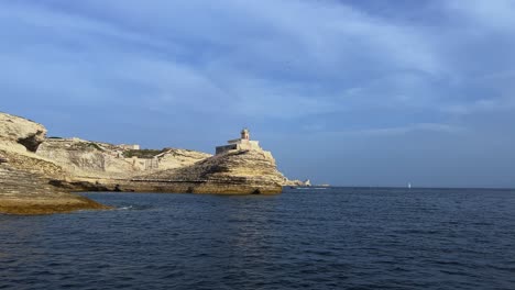Sea-surface-pov-of-famous-Madonnetta-lighthouse-built-on-rock-in-Southern-Corsica-island-seen-from-touristic-boat