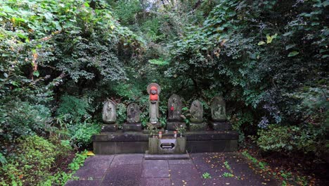 Una-Ermita-Muy-Antigua-En-Un-Templo-Budista-Zen-En-Tokio,-Los-Budas-Están-Rodeados-De-Un-Verde-Muy-Intenso-En-La-Temporada-De-Verano