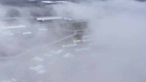 Mist-covering-residential-town-of-Njardvik-in-Iceland,-aerial
