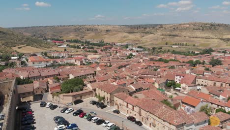 Aerial-view-of-Siguenza,-Spain,-with-its-red-tile-roof-houses-and-some-farm-fields-in-the-horizon