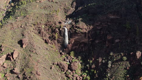 Fantastic-aerial-shot-in-distance-of-a-beautiful-waterfall-in-the-mountains-and-caused-by-the-heavy-rains-of-Cyclone-Hermine-on-the-island-of-Gran-Canaria-recently