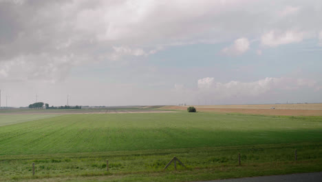 In-this-countryside-timelapse-in-the-Dutch-polder,-we-see-clouds-moving-their-shadows-over-the-grasslands