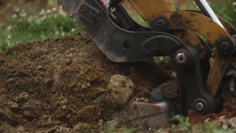Excavator-pushing-through-rocks-and-soil-dirt