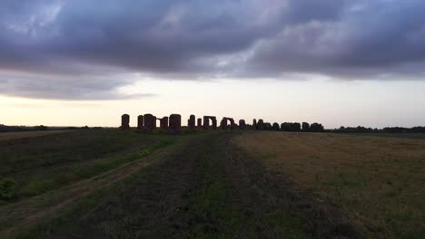 Ancient-barn-ruins-in-middle-of-the-field,-stonehenge-like-heritage,-aerial-dolly-in