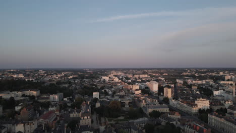 Drone-flying-over-Rennes-city-at-sunset,-France
