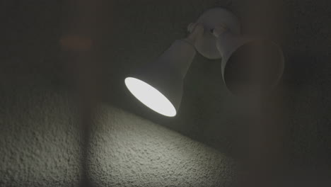 Two-white-color-led-light-cone-is-installed-in-the-grey-wall-out-of-which-only-one-is-switched-on