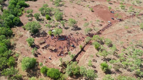 Drone-view-of-people-arriving-at-the-cermony-site-at-the-end-of-the-Freedom-Day-Festival-march-in-the-remote-community-of-Kalkaringi,-Northern-Territory,-Australia