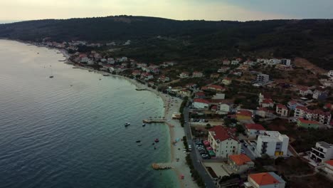 4K-Luftaufnahmen-Von-Drohnen,-Die-Von-Einem-Kroatischen-Strand-über-Der-Stadt-Am-Strand-Aufsteigen