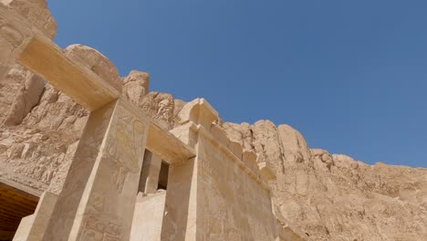 Vista-De-Los-Dibujos-En-Las-Paredes-Del-Templo-De-La-Reina-Hatshepsut-Y-Los-Acantilados-En-El-Desierto
