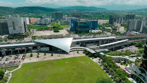 Vista-Aérea-De-La-Futurista-Estación-Ferroviaria-De-Alta-Velocidad-De-Taiwán-Con-Montañas-En-El-Fondo--taiwán-Hsinchu-Hse-Estación-Ferroviaria-De-Alta-Velocidad-En-Taipei