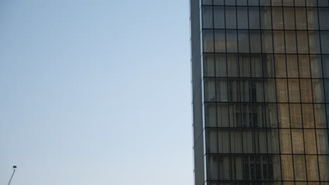 Tall-glass-building-in-Paris-with-reflections-in-windows-and-surrounding-construction