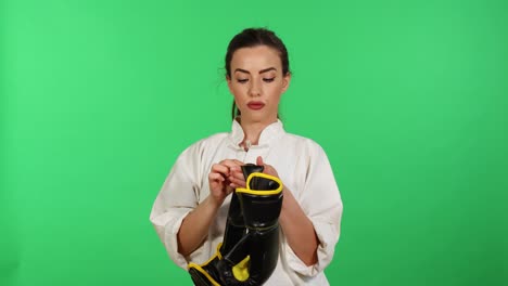 Hübsche-Frau-In-Kung-Fu-Wushu-Uniform,-Die-Boxhandschuhe-Hält,-Während-Sie-In-Die-Kamera-Schaut