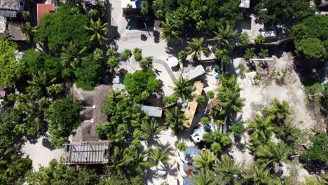Truck-driving-on-a-coastal-road-in-Tulum-Hotel-Zone-along-the-beach-on-a-sunny-day,-aerial-top-down