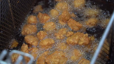 Delicious-crunchy-and-crispy-karaage-chicken,-korean-fried-chicken-cooking-in-progress,-deep-frying-in-boiling-hot-oil-fast-food-commercial-kitchen,-night-market-pub-food,-close-up-shot