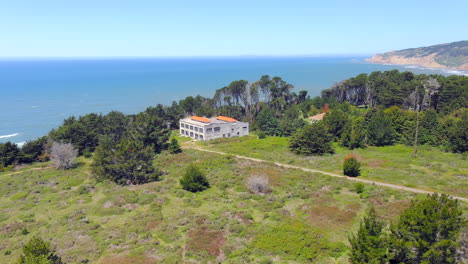 House-on-a-cliff-with-an-ocean-view-of-California-coast,-aerial-view