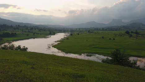 Paisaje-Tranquilo-De-Campos-Verdes-Y-Lago-Vaitarna-En-Maharashtra,-India---Amplio