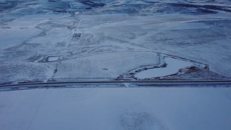 Tilt-up-to-the-Rocky-Mountains-over-highway-in-winter-time-with-a-lot-of-snow