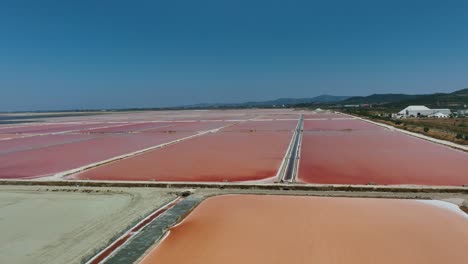 Luftaufnahme-Mit-Blick-Auf-Rote-Salzproduktionsteiche-Im-Sonnigen-Albanien---Panorama,-Drohnenaufnahme