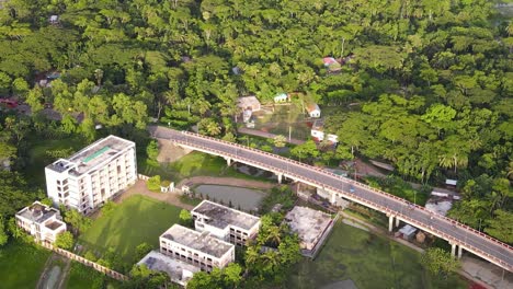 View-from-above-of-Concrete-viaduct-road-surrounded-by-dense-tropical-forest,-Bangladesh