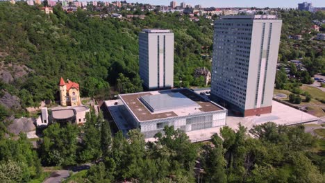 Aerial-drone-view-of-Faculty-of-Humanities-Charles-University-in-Prague,-Czech-Republic,-traffic-in-background