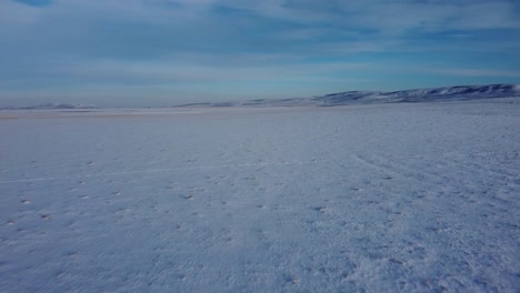 Flying-straight-over-snowy-field-in-winter-time-in-Canada