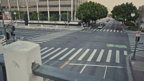 Eine-Von-Hohen-Gebäuden-Gesäumte-Kreuzung-In-Der-Nähe-Des-Gerichtsgebäudes-Und-Des-Rathauses-In-Los-Angeles,-An-Der-Zahlreiche-Autos-Ihrem-Ziel-Entgegenfahren