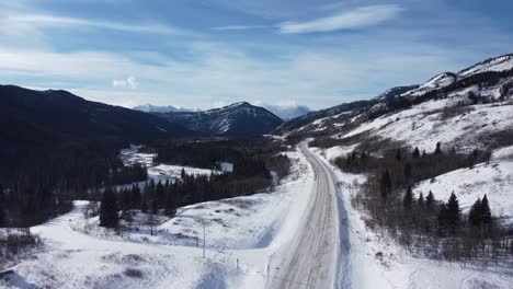 Foto-Reveladora-De-La-Carretera-Vacía-Con-Montañas-En-El-Fondo-Con-Mucha-Nieve