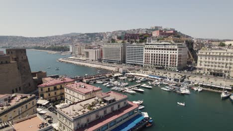 Drone-flyover-Naples-marina-revealing-scenic-coastline-city,-travel-destination