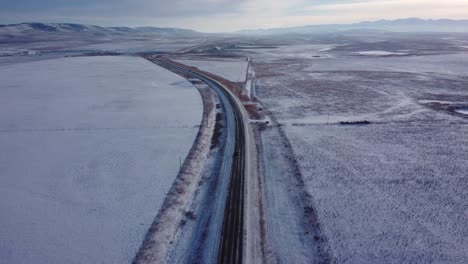 Winter-highway-bird-view-shot-in-hilly-farmers-fields-area