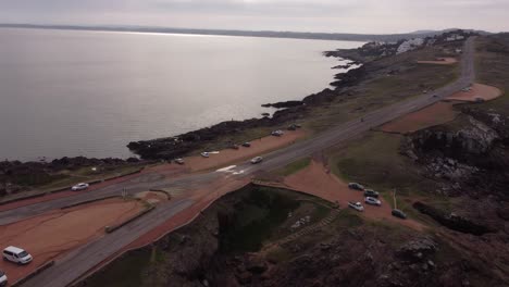 Cars-parking-along-coastal-and-panoramic-road-ocean-view,-Punta-Ballena-peninsula-in-Uruguay