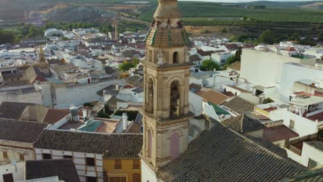 Aerial-View,-Iglesia-de-la-Concepcion,-Catholic-Church-Bell-Tower-and-Puente-Genil,-Spain-Cityscape-on-Sunny-Day,-Cinematic-Revealing-Drone-Shot