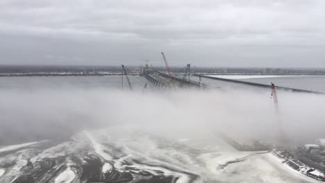 Construction-cranes-in-extreme-foggy-winter-weather-demolishing-old-Champlain-bridge,-Canada-infrastructure,-time-lapse