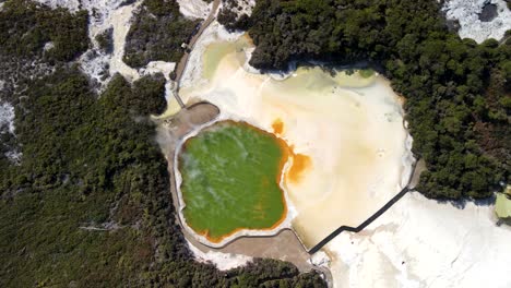 Beautiful-aerial-of-colorful-steaming-lake-in-Waiotapu,-Rotorua,-New-Zealand