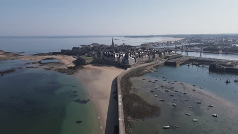 Drone-flying-over-Plage-du-mole-or-pier-beach-during-low-tide,-Brittany-in-France