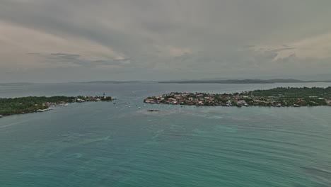 Bocas-del-Toro-Panama-Aerial-v14-exotic-summer-view,-flyover-towards-small-island-town-capturing-sailboats-and-yachts-sailing-on-beautiful-turquoise-sea-water---Shot-with-Mavic-3-Cine---April-2022