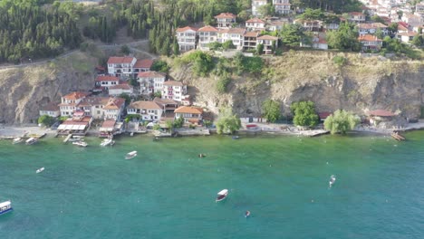 Summer-Coast-of-Lake-Ohrid-North-Macedonia-homes-and-boats-on-water,-drone