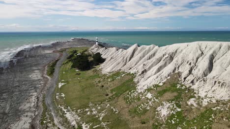 Faro-Bellamente-Ubicado-En-Cape-Campbell,-Pintoresco-Paisaje-Costero-De-Nueva-Zelanda---Drone