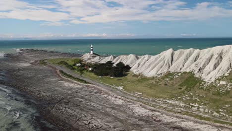 Aerial-panoramic-of-remote-lighthouse-and-white-cliff-on-New-Zealand-coastline