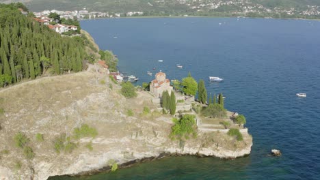 Drone-Volando-Desde-El-Cielo-Hacia-El-Agua-Mostrando-La-Belleza-De-La-Iglesia-De-San-Juan-Ohrid-Macedonia-Del-Norte