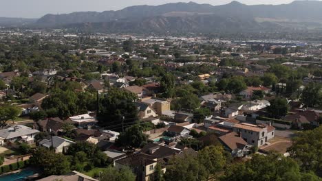 Suburb-in-Burbank,-California-at-the-base-of-picturesque-and-iconic-Hollywood-mountains-and-foothills---ascending-aerial-view