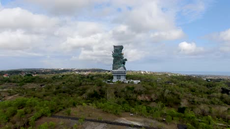 High-statue-of-Garuda-Wisnu-Kencana-in-Bali-island,-aerial-fly-toward-view