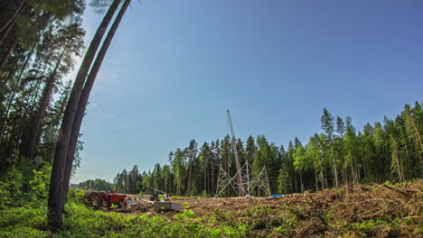 Motion-Timelapse-Of-A-Pylon-Tower-Being-Built-On-Rural-Landscape-With-Forest-Trees-In-Background