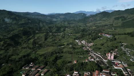 Aerial-view-of-Jerico-little-town-in-Colombia-Antioquia-department-in-andes-mountains,-green-valley-with-traditional-village-and-old-church-cathedral-drone-fly-above