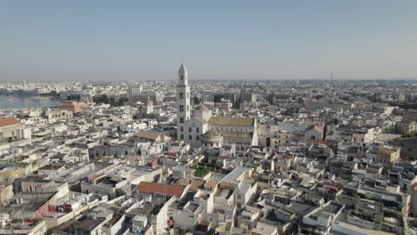 Aerial-view-of-the-maritime-city-Bari-and-the-Bari-cathedral-tower,-approaching-the-church-tower