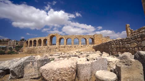 Arches-of-Hippodrome-wall-and-Jerash-ancient-city-in-Jordan,-tilt-up