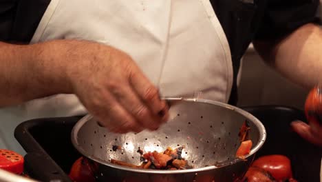 Chef-Peeling-Roasted-Tomatoes-For-Salsa-At-A-Restaurant