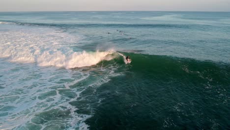 Vista-Aérea-De-Un-Surfista-Profesional-Atrapando-Las-Olas-Del-Océano-En-Uluwatu-Indonesia-Bali-Island-Paradise